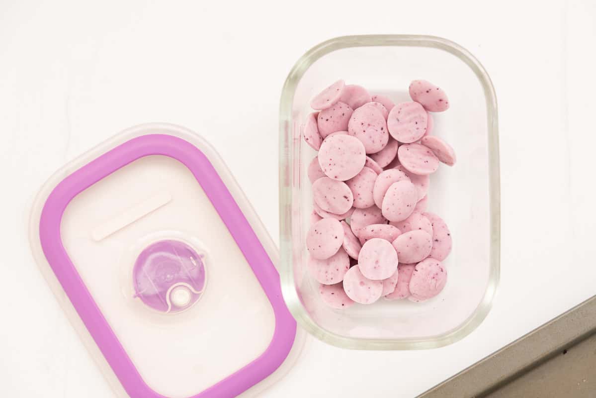 Pale purple baby yogurt melts in a glass container with lid, ready to go into the freezer.