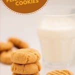 A stack of 3 peanut butter cookies next to a glass of milk