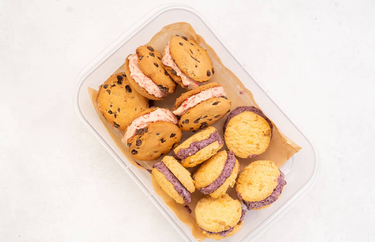 Strawberry and Blueberry gluten free ice cream sandwiches in a container ready to store in the freezer.