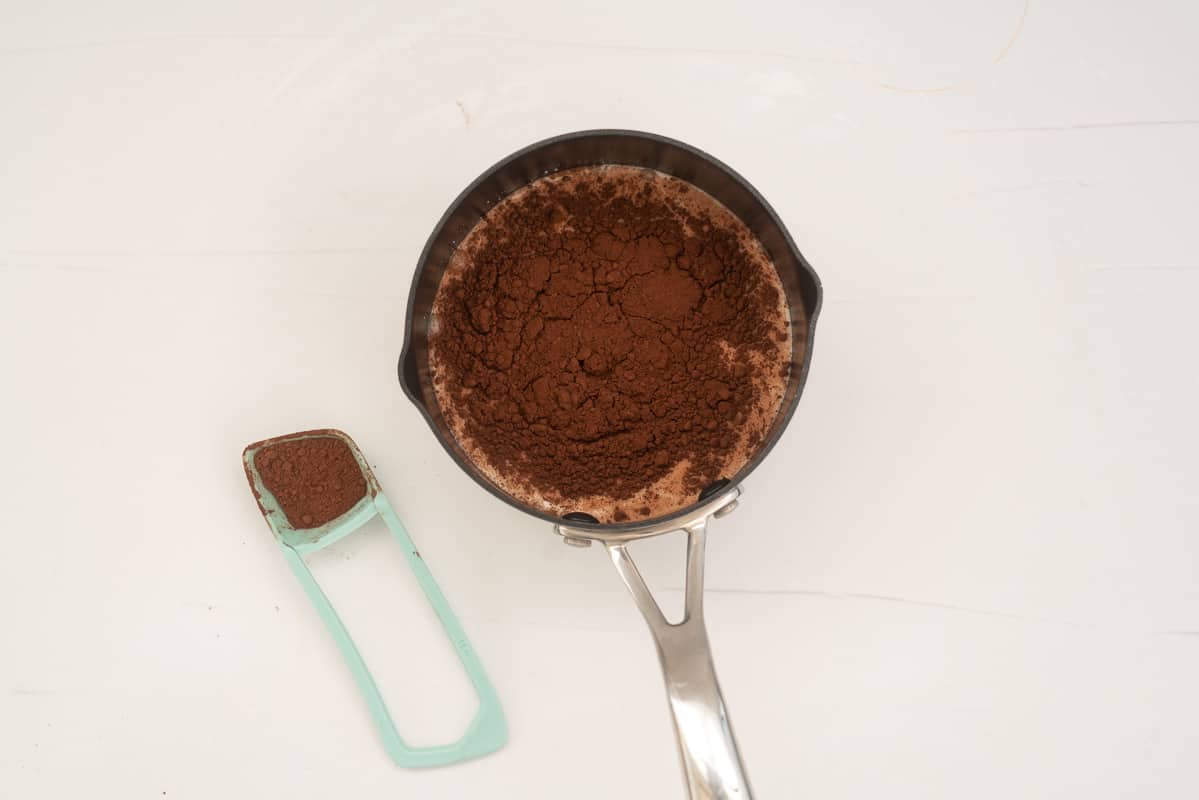 A saucepan filled with milk and cocoa powder.