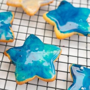 Blue galaxy iced cookies on a cooling rack.
