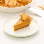 A slice of sweet potato pie decporated with a pastry star on a white plate.