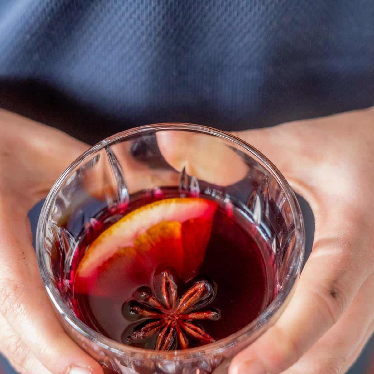 Child holding a glass of non-alcoholic mulled wine in two hands