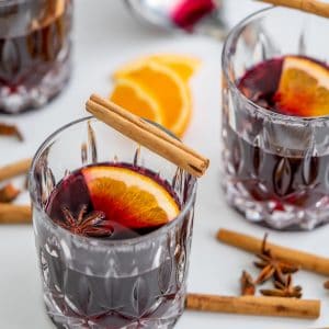 non-alcoholic mulled wine in3 cut glass tumblers, served with star anise, orange slices and cinnamon quills.