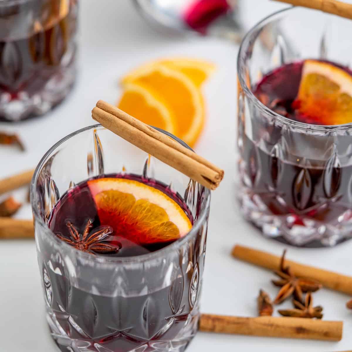 non-alcoholic mulled wine in3 cut glass tumblers, served with star anise, orange slices and cinnamon quills. 