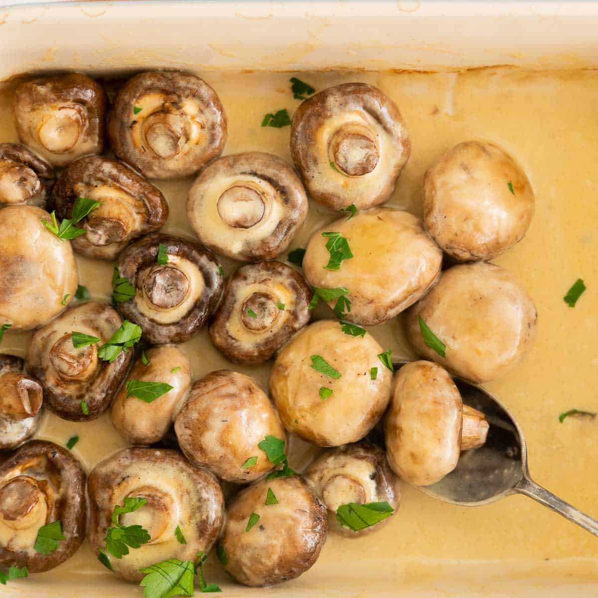 Mushrooms in a creamy sauce garnished with chopped parsley.