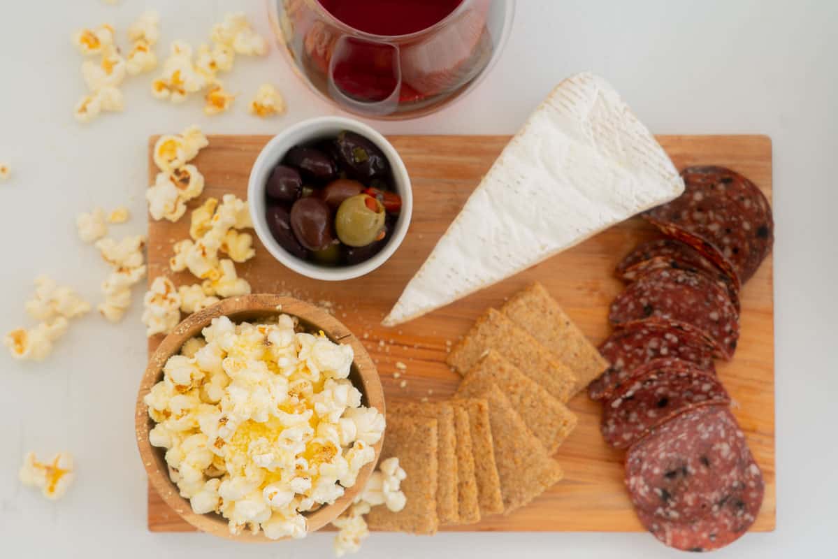 An antipasto platter with cheese popcorn, olives, and salami.