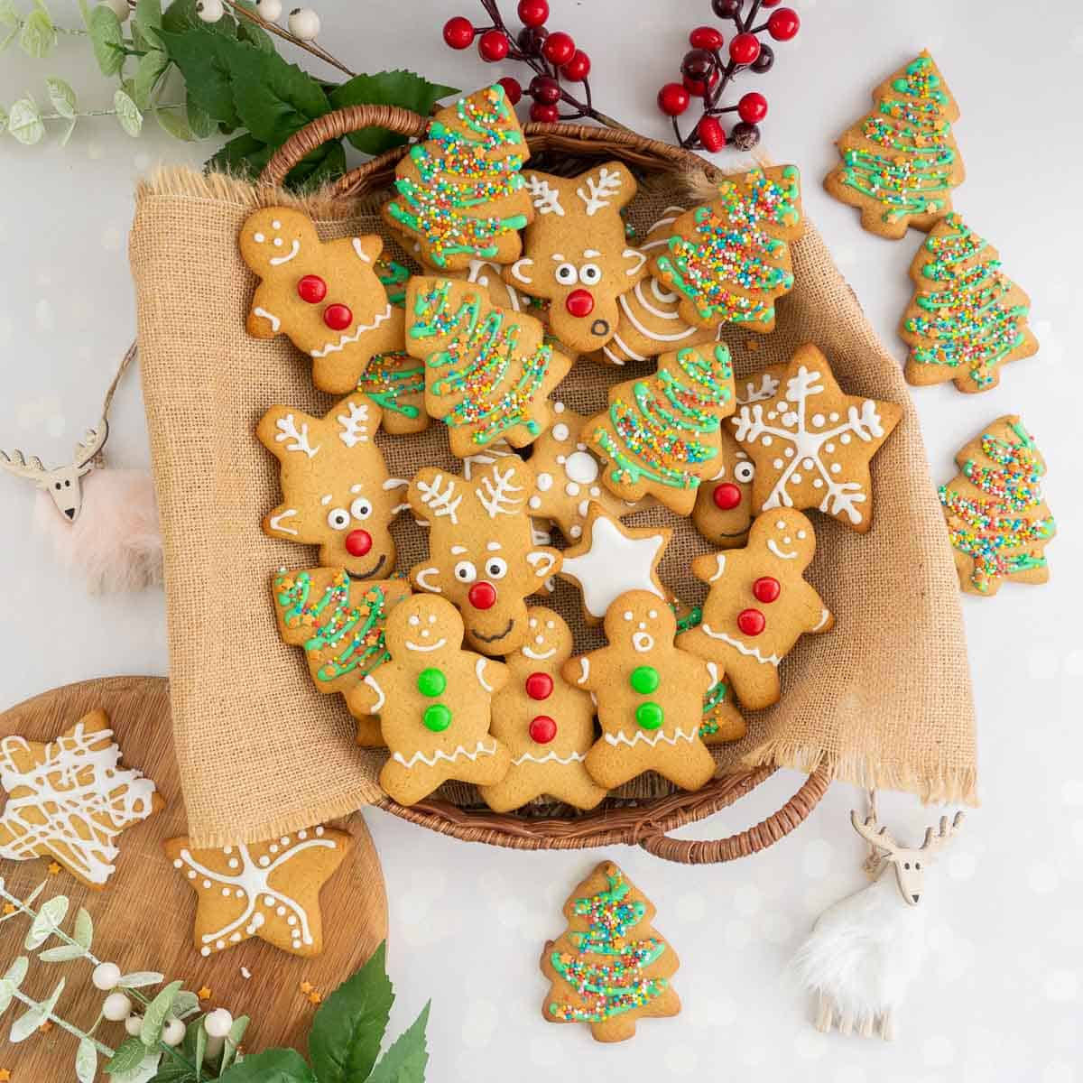 A round basket filled with a variety of decorated gingerbread cookies.