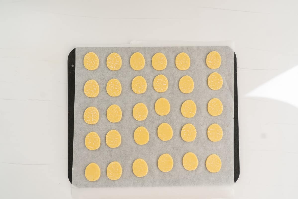 oval shaped cookies on a lined baking sheet.