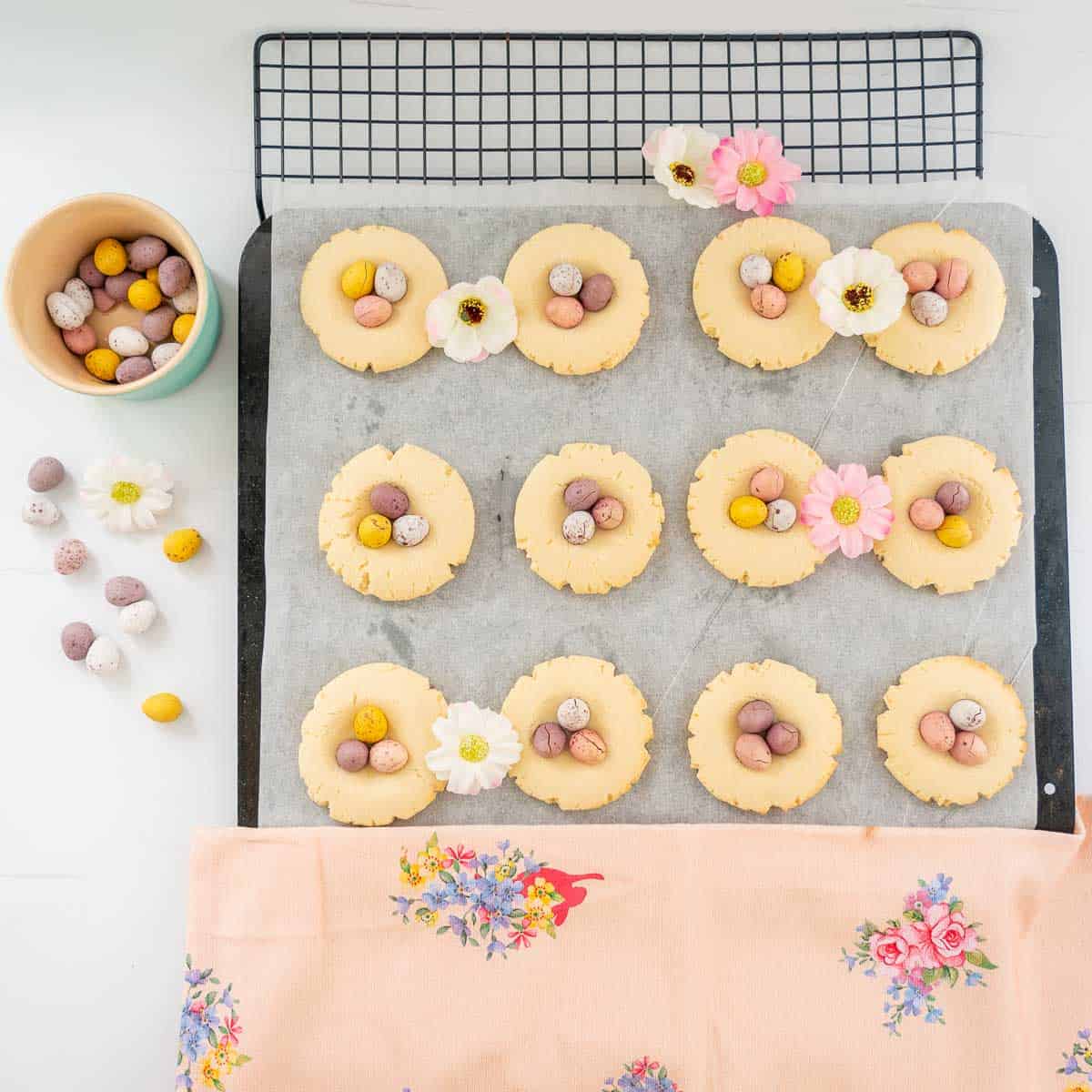 A baking sheet with 12 mini egg cookies on a cooling rack.