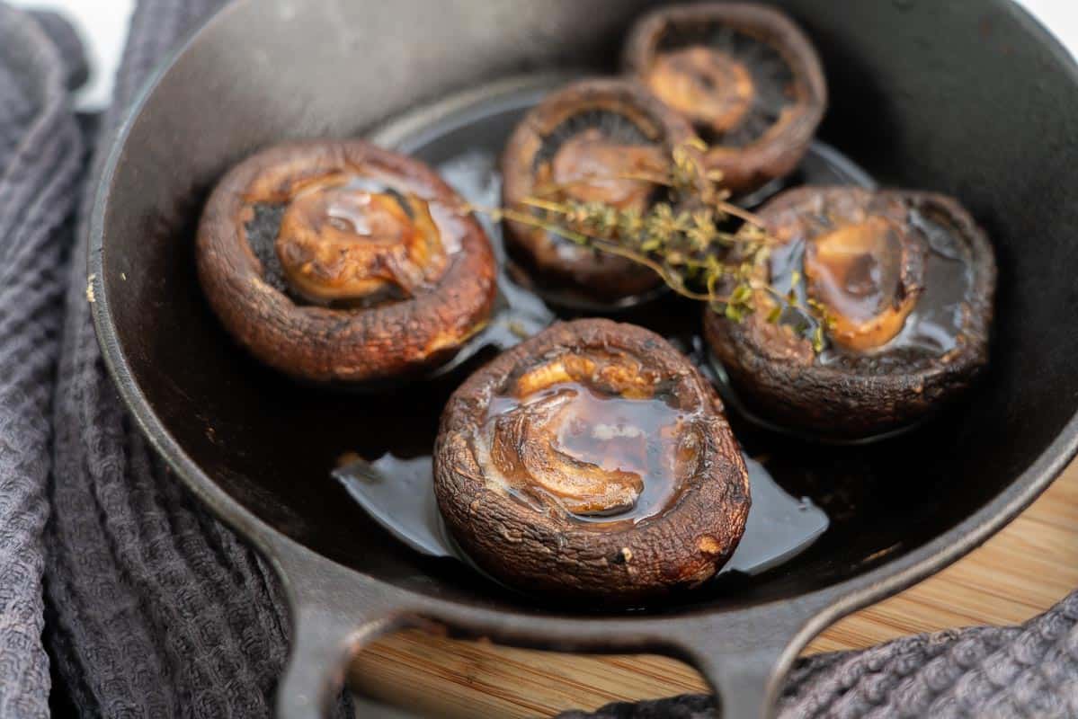 Large roasted mushrooms in a black cast iron dish.