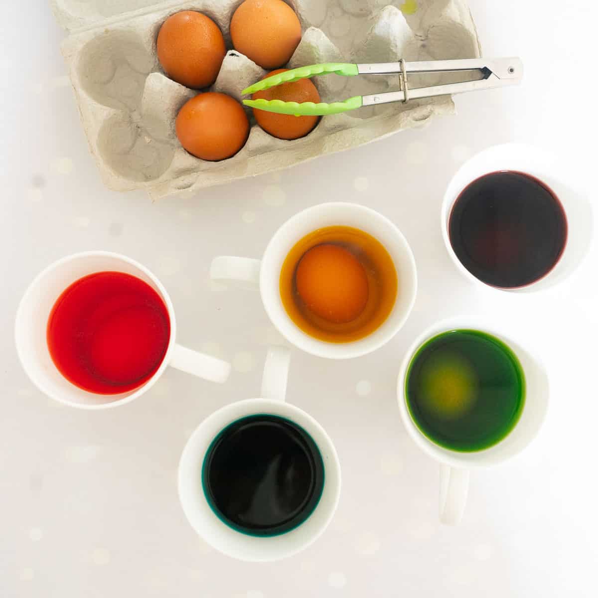 5 Eggs soaking in food colouring.