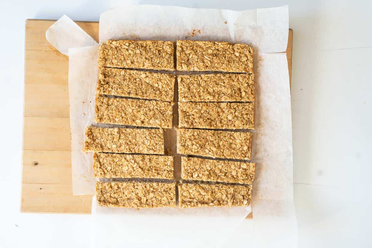 12 soft oat bars on a wooden chopping board.
