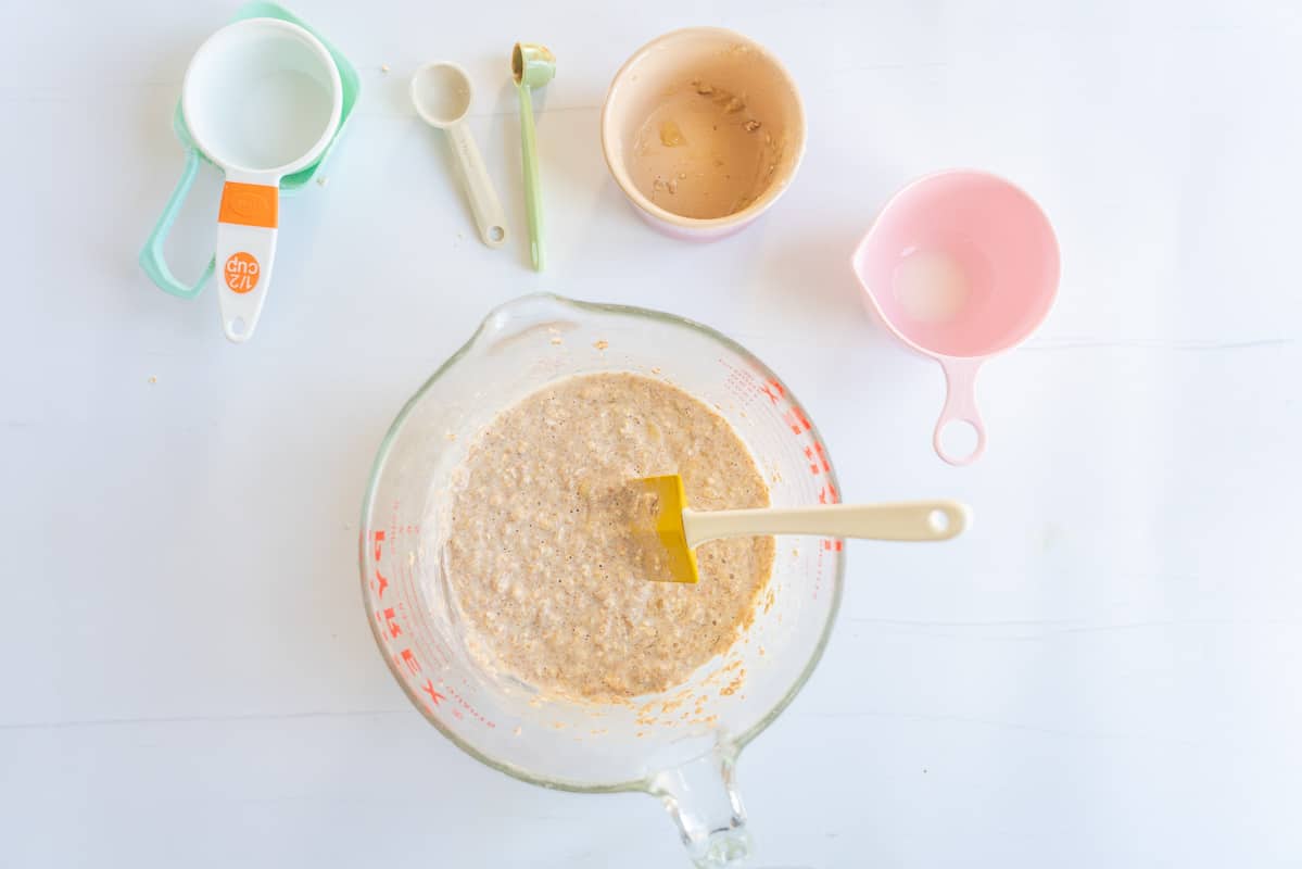 Banana oat pikelet batter in a mixing jug with a spatula. 