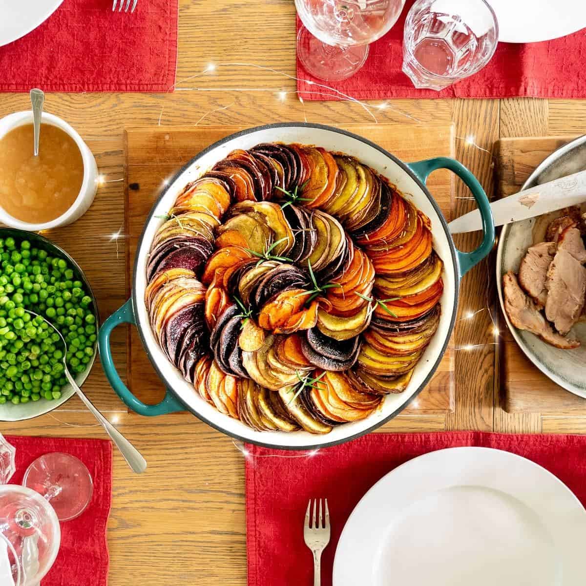 Colourful slices of kumara baked in a large ceramic dish in the centre of a family dining table.
