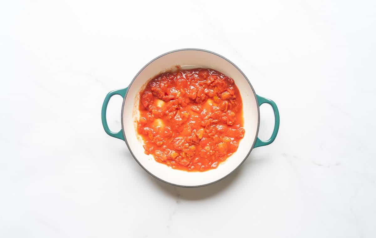 Diced tomatoes in the bottom of a large casserole dish. 