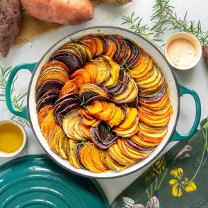 Colourful slices of kumara baked in a large ceramic dish.