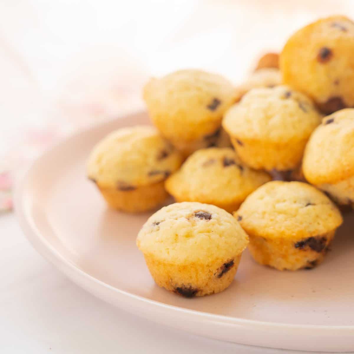 Mini muffins piled on a pink plate.