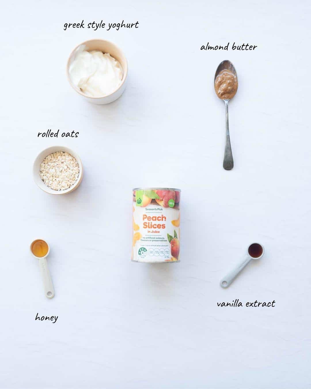 The ingredients to make peach overnight oats laid out on a white bench top with text overlay.