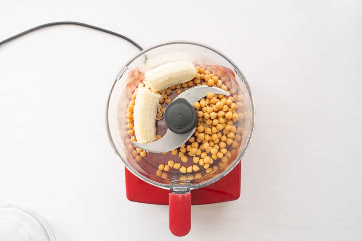Chickpeas and banana in a food processor ready to blend.