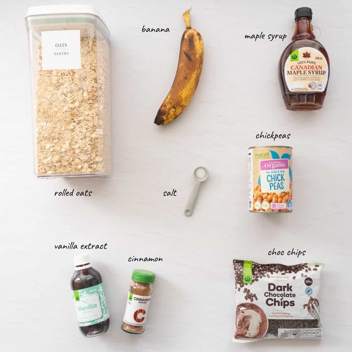 The ingredients to make banana energy bites laid out on a bench top with text overlay.