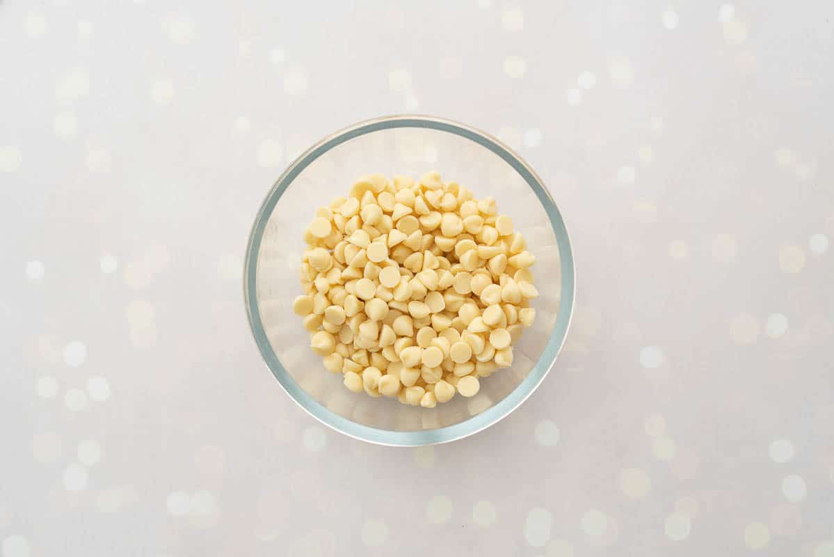 White chocolate drops in a glass mixing bowl.