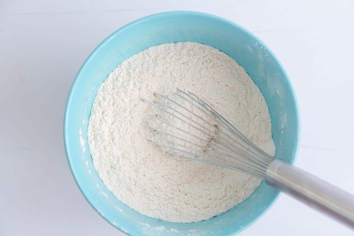 Dry ingredients whisked together in a light blue mixing bowl. 