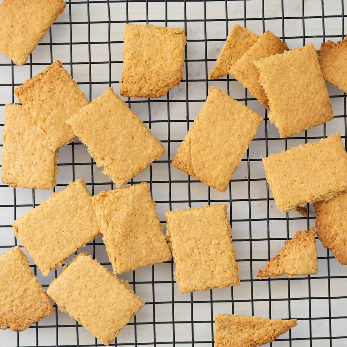 Golden brown rectangular oat crackers on a cooling rack. 