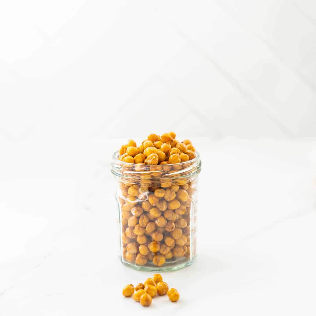 A glass jar overfull of roasted chickpeas