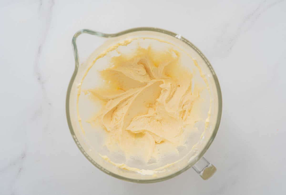 Creamed butter and sugar in a glass jug mixing bowl for a stand mixer. 