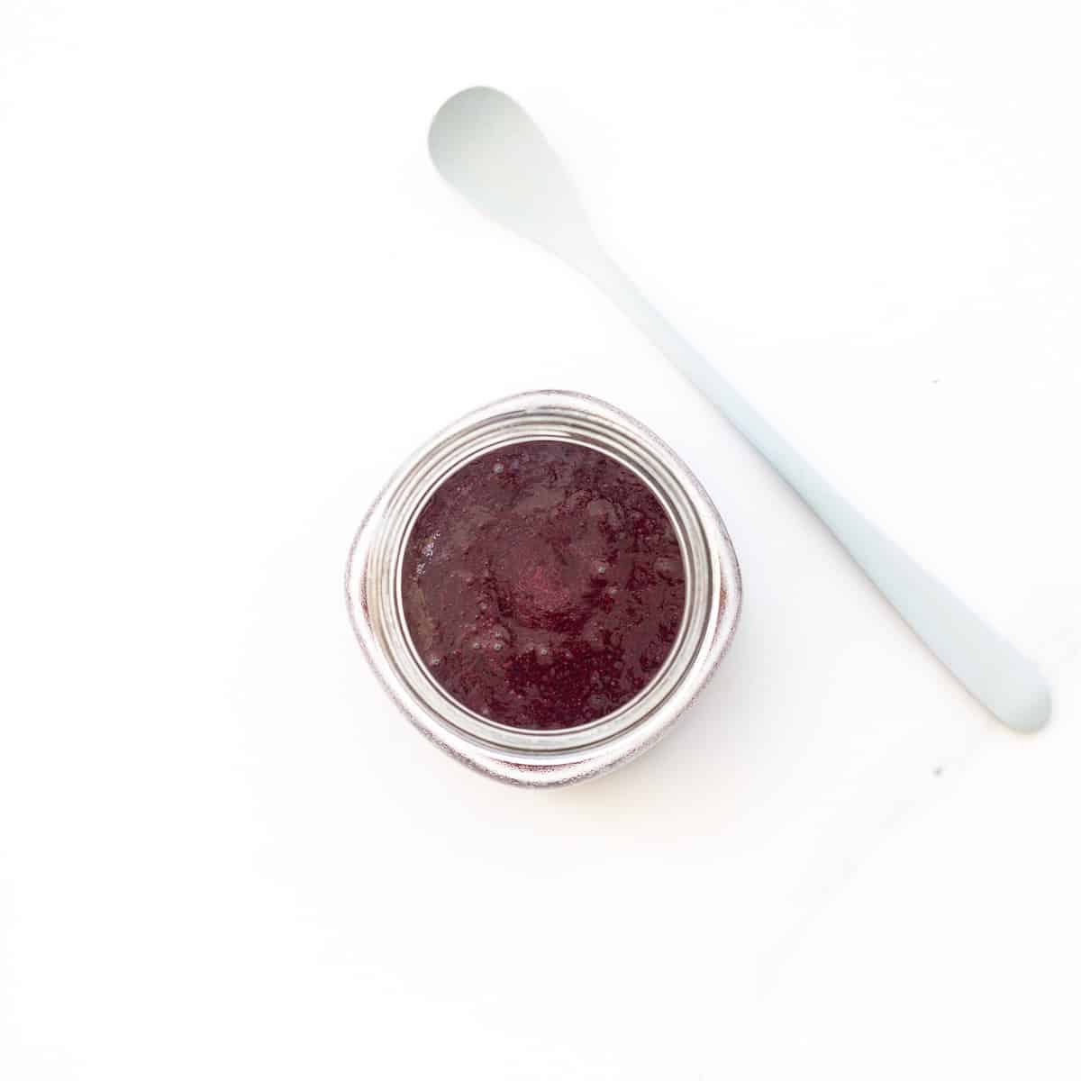 Looking down into a glass jar of blueberry puree.