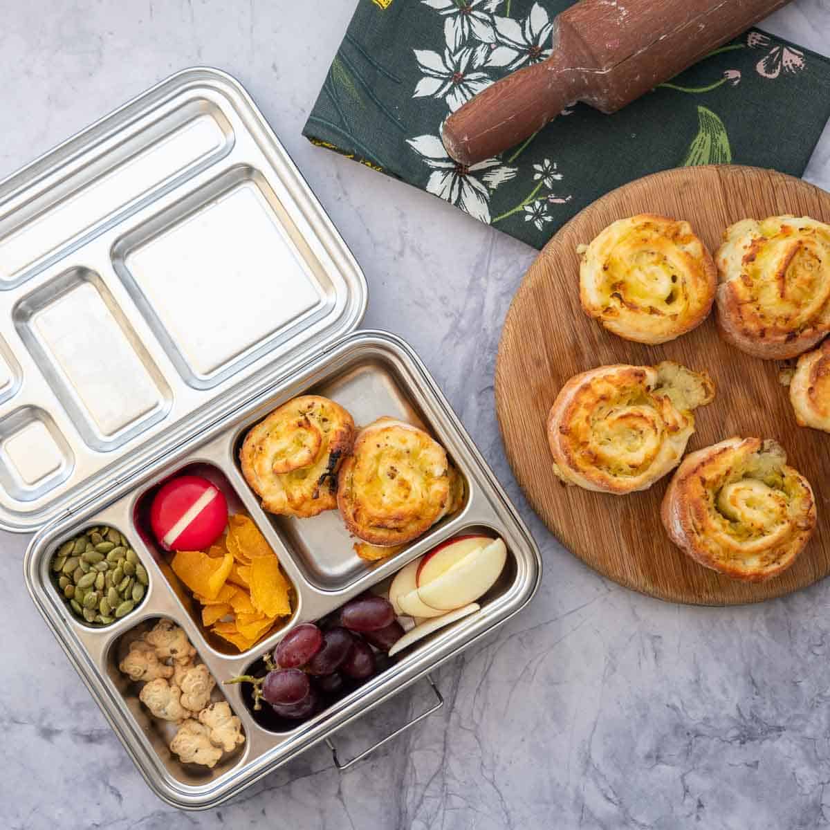 Gluten free scrolls packed into a stainless steel lunch box with other lunch box items.