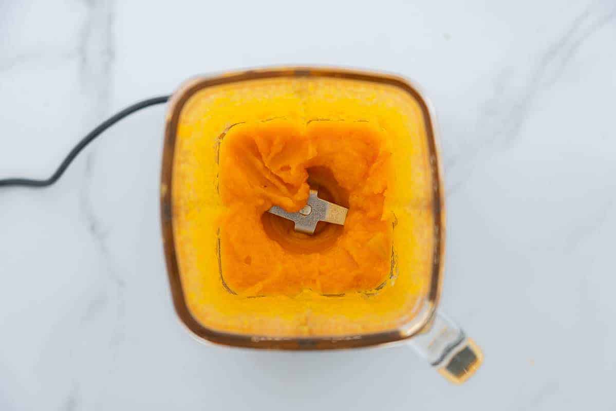 Looking into the blender with smooth orange puree.