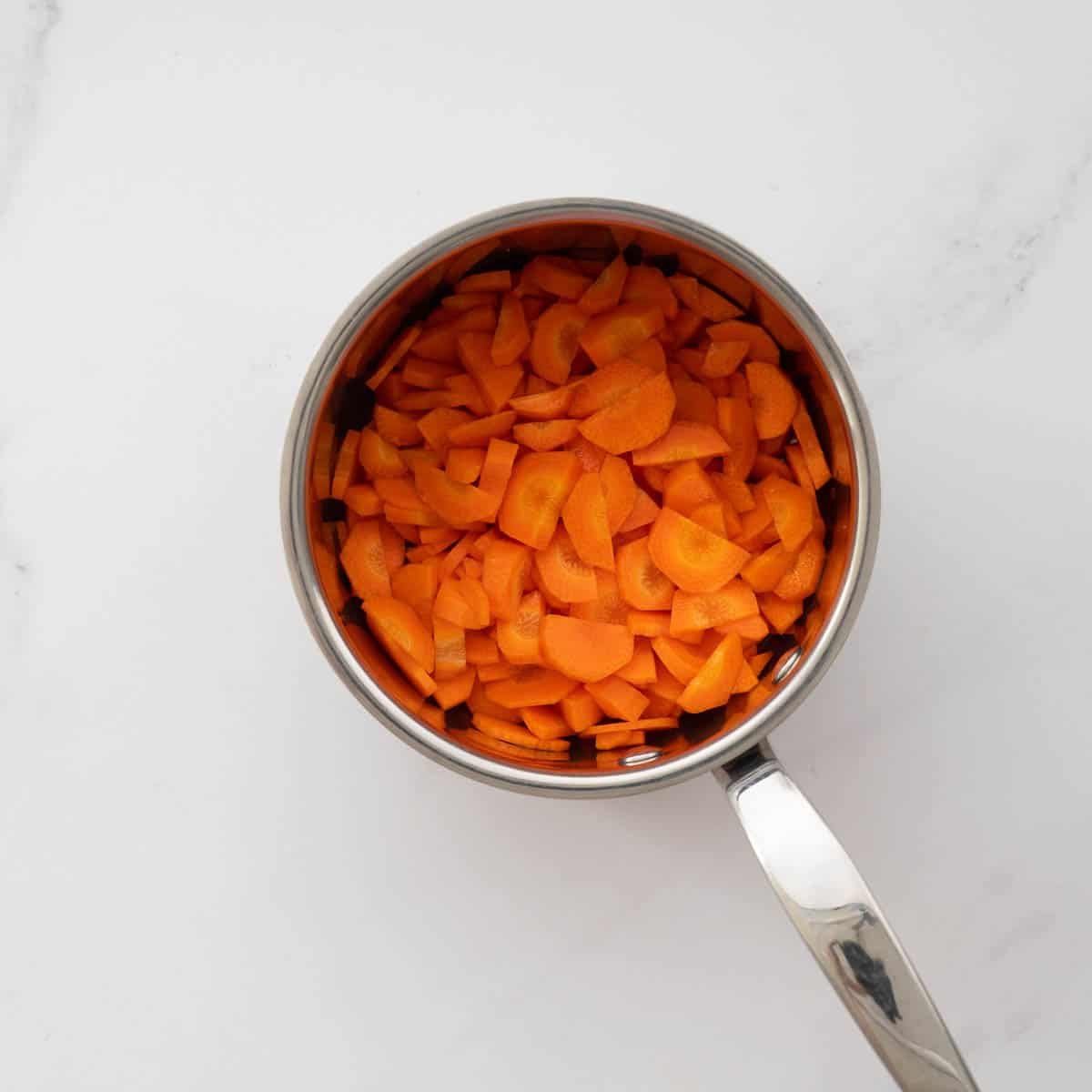 A saucepan filled with carrot slices. 