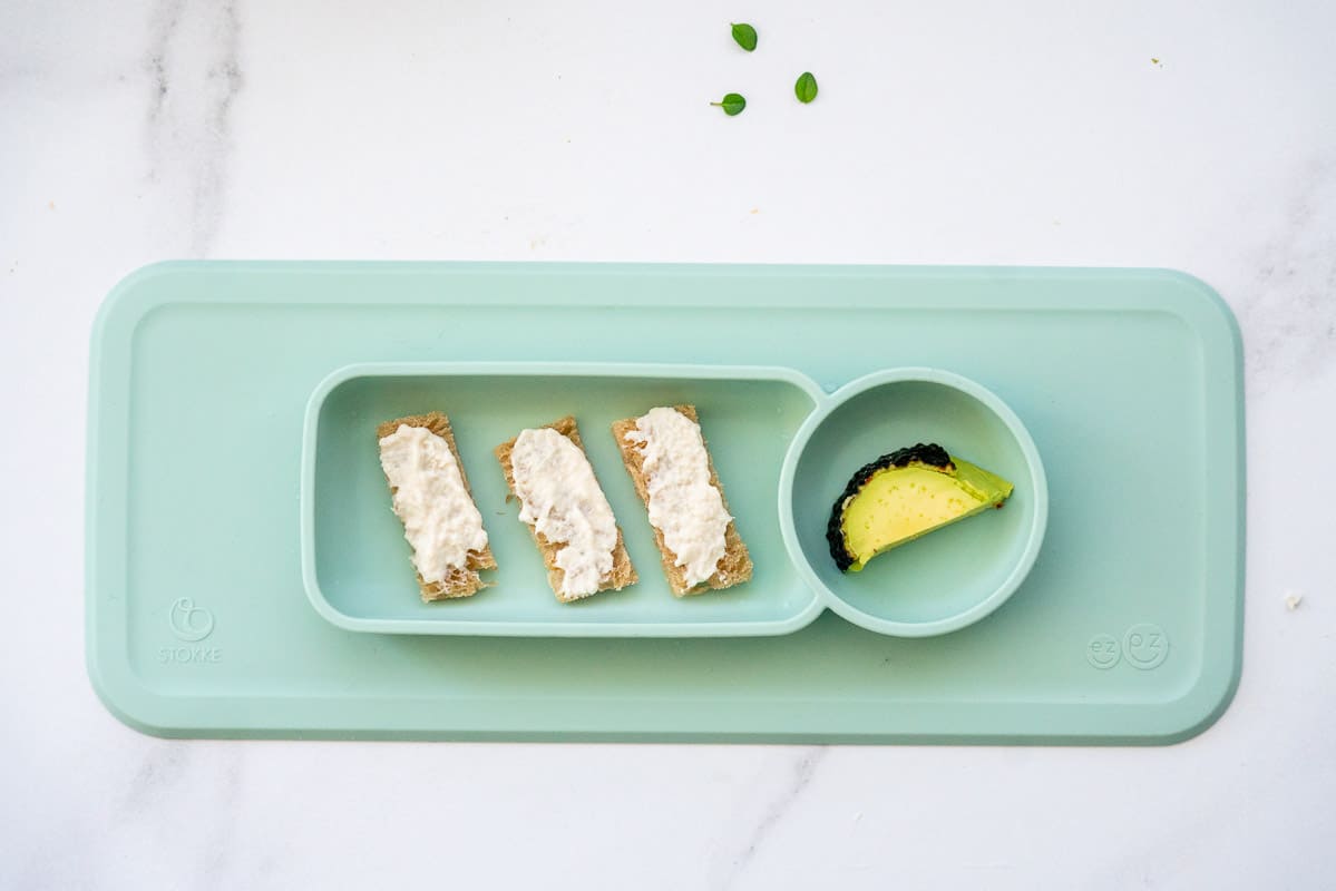 Chicken paste spread on toast batons on a green baby tray.
