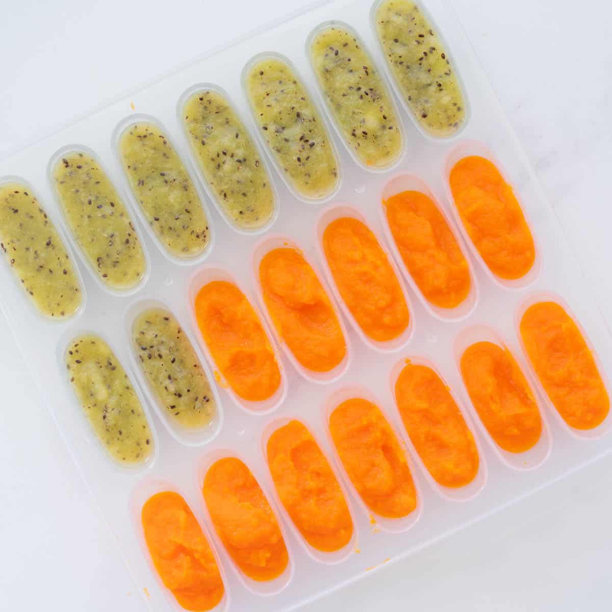 A baby food tray filled with both carrot and kiwi puree.