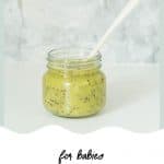 A small glass jar filled with kiwifruit puree in front of a grey marble splashback with text overlay for pinterest.