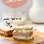 Shredded chicken sandwiches stacked on a wooden board and held together with a bamboo toothpick with text overlay for pinterest.