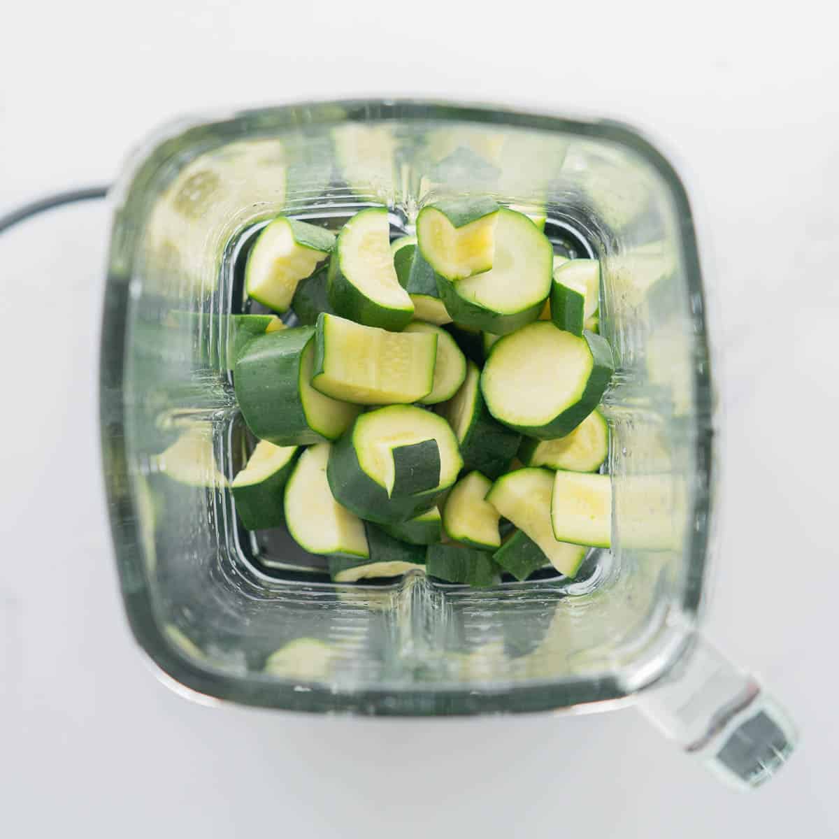 Steamed slices of zucchini in a glass blender jug.