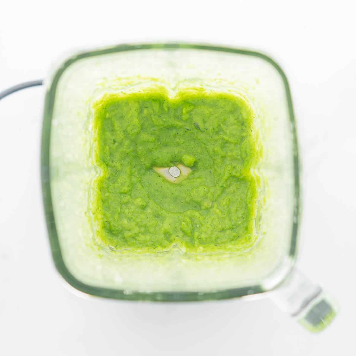 Green vegetable puree in a glass blender jug.