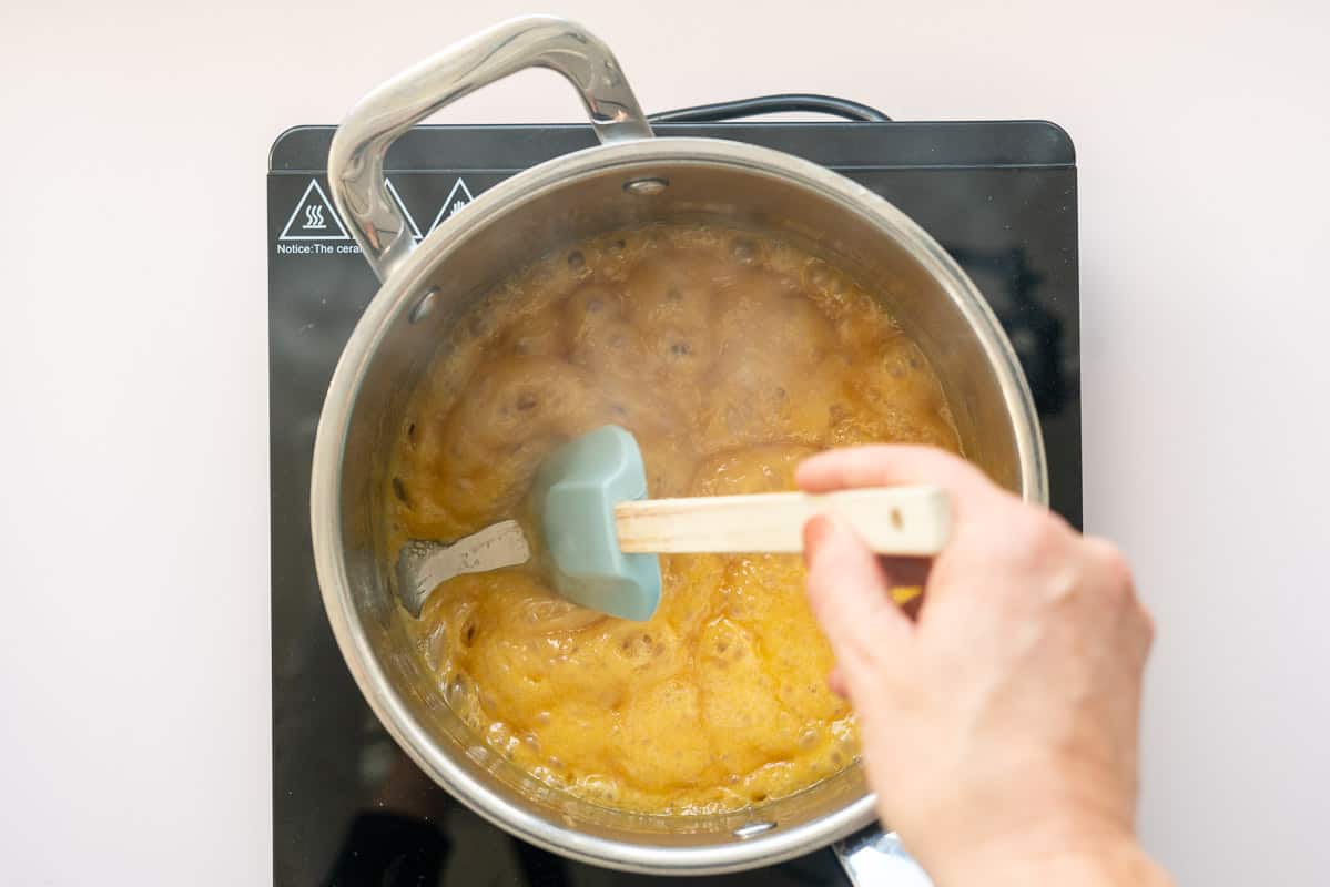 Foaming caramel in the bottom of a saucepan.