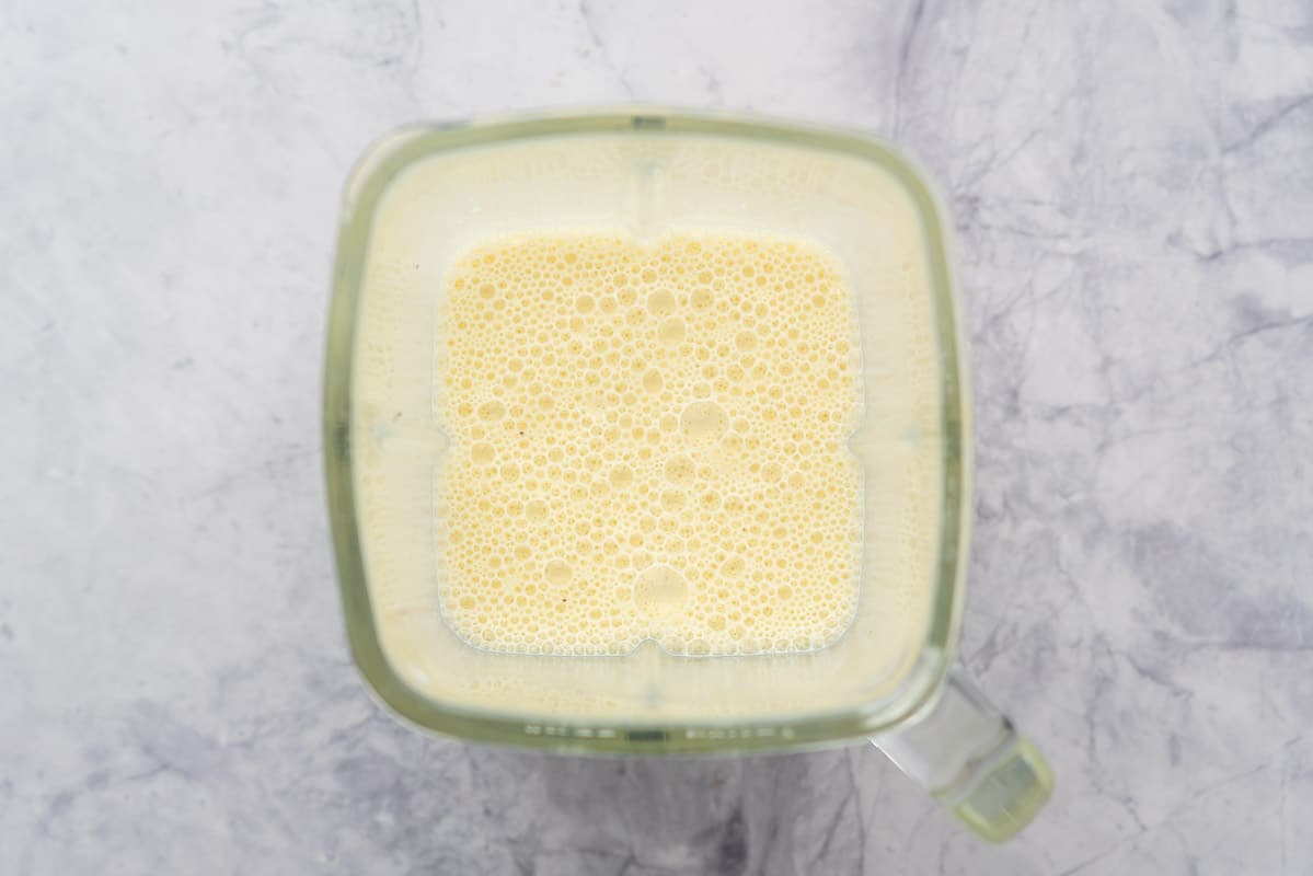 Frothy pale yellow milk in a blender jug.