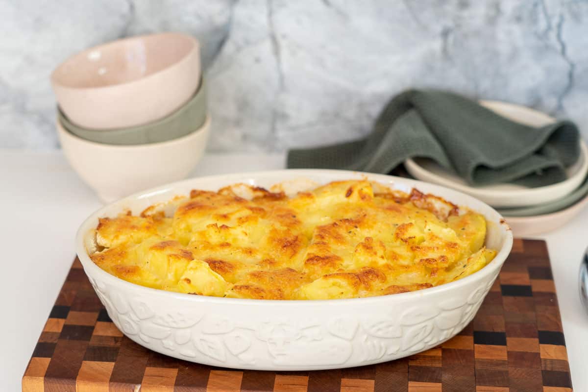An oval baking dish of golden baked scalloped potatoes.
