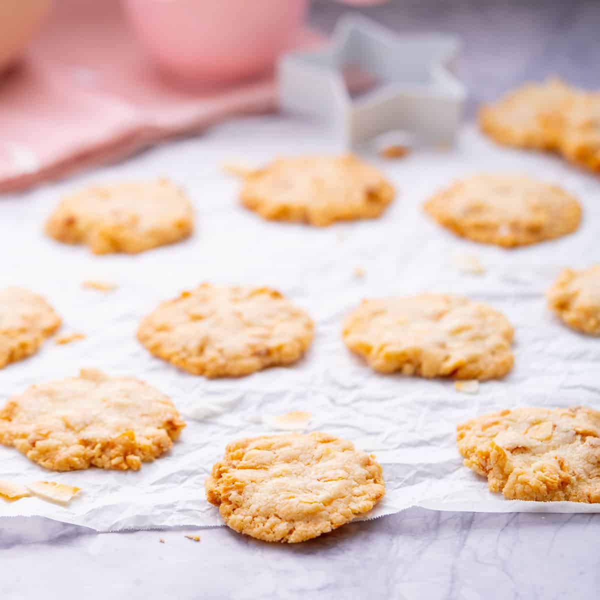 Baked Gluten Free Coconut Cookies sitting on crinkled baking paper on the bench