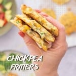 A hand holding a stack of three fritters that have had a mouthful taken from them to reveal chickpeas, corn and zucchini inside with text overlay for pinterest