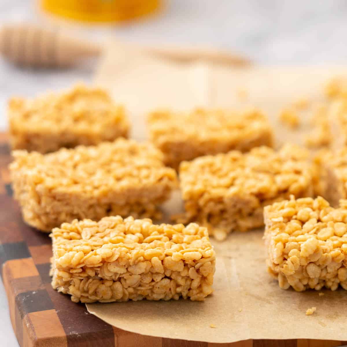 Rice krispie bars laid out on baking paper. 