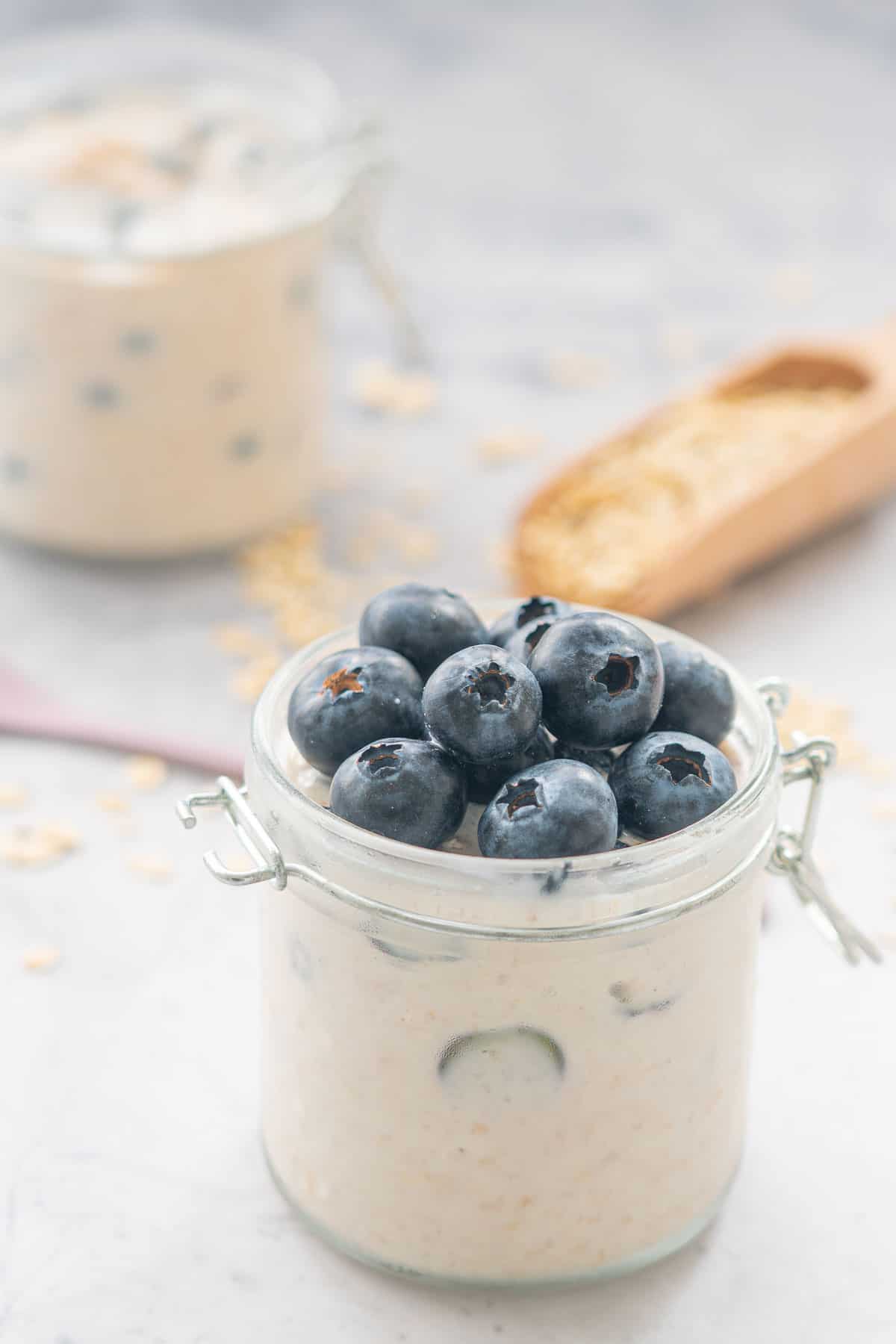 One portion of blueberry overnight oats with a scattering of whole blueberries on top  