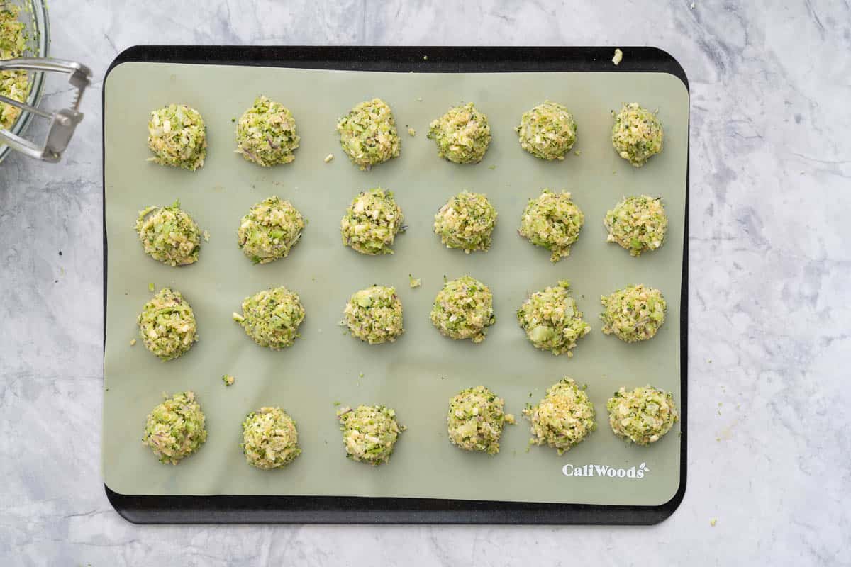 Tablespoons full of the broccoli mixture rolled into balls and placed on a lined baking tray