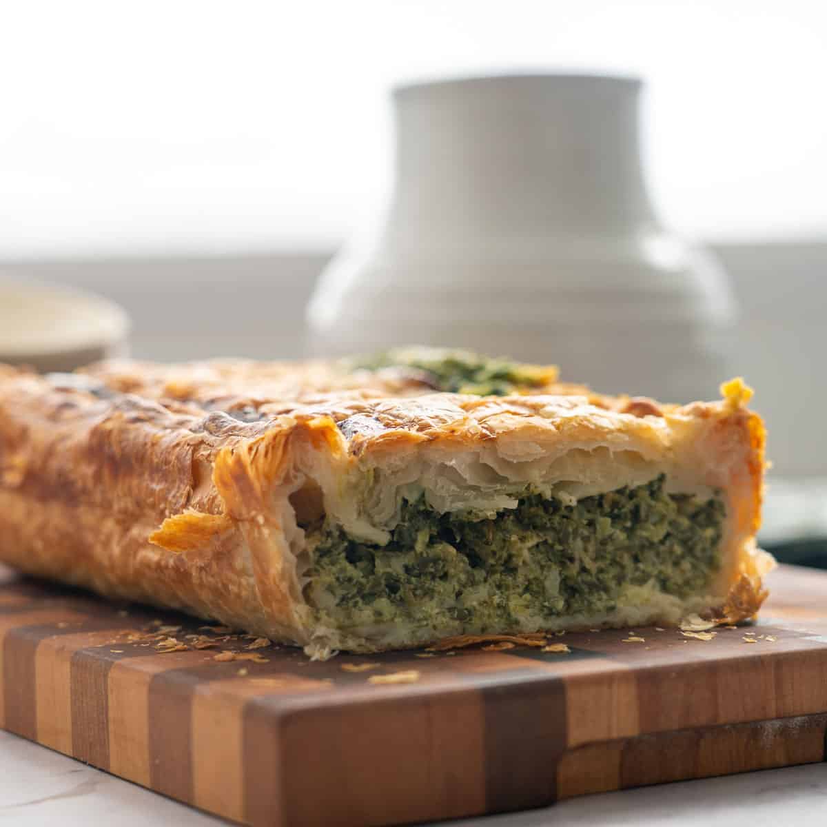 A pie with spinach filling cut into to show the vibrant green filling. 