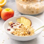 A bowl of bircher muesli on a marble bench top.